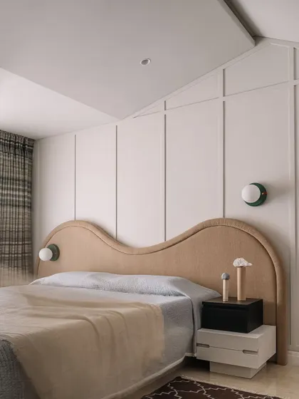 The guest bedroom's unique headboard and wall paneling create a cozy, attic-like feel, making it a welcoming retreat for visitors.