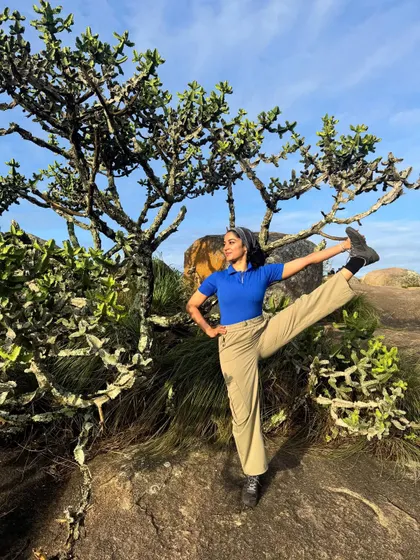 A standing leg extension pose amidst the unique trees on the Uttari Betta trail. Yoga isn't just for the mat; it's about finding moments of mindful movement wherever you are.