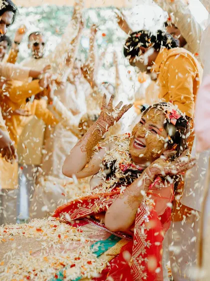 An explosion of laughter and flower petals as the bride enjoys her Haldi ceremony to the fullest.