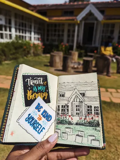 A page from my travel journal, featuring a sketch of a beautiful homestay in Chikmagalur alongside some motivational stickers. My journal is a mix of art and memories.