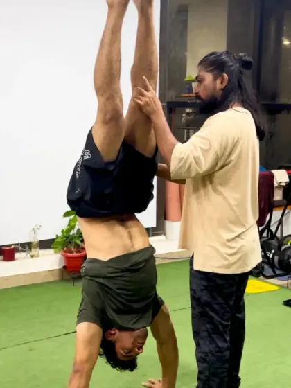 A coach providing support during a handstand practice. We're here to spot you, guide you, and help you nail those skills safely.