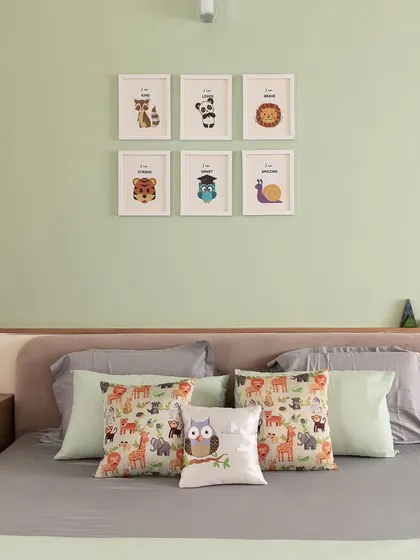 The kid's bedroom in 'A Walk in the Clouds' features a queen-size bed with a simple upholstered headboard. The pastel green wall and animal-themed decor create a sweet and dreamy atmosphere.