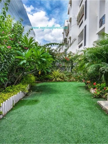 Even narrow spaces between buildings can become beautiful gardens. I designed this long, green corridor with an artificial turf lawn and dense border plantings to create a private and pleasant walkway.