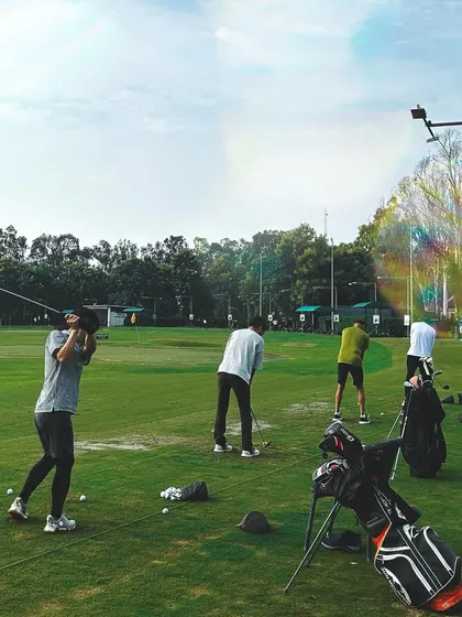 With a sprawling driving range, there's space for everyone. This shot captures the energy of a busy day, with multiple players enjoying the game side-by-side, making it ideal for large group events.