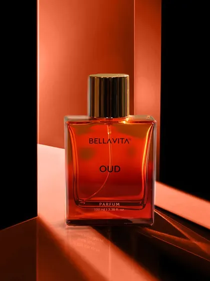A sleek, modern product shot of a perfume bottle using reflective surfaces and dramatic lighting to create a high-end, architectural look.