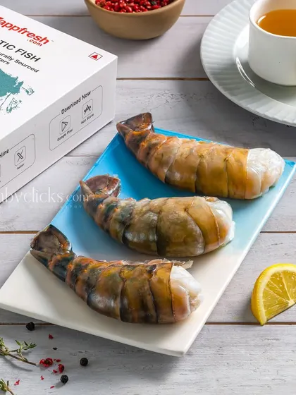 Large raw tiger prawns on a plate, shown next to the Zappfresh packaging to connect the product with the brand.