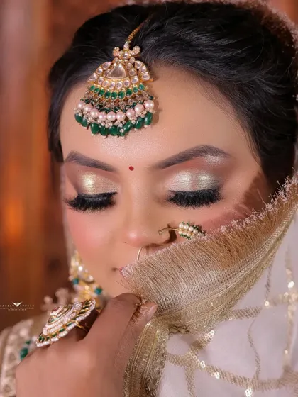 A dreamy close-up with the bride's eyes closed, as if lost in thought. The focus is on her stunning metallic eyeshadow and the intricate details of her jewellery.