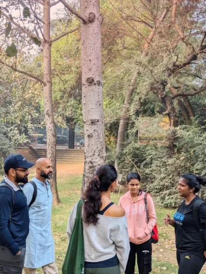 A small group pauses to connect and share during our mindful walk in the forest. It's a chance to build community while surrounded by nature.