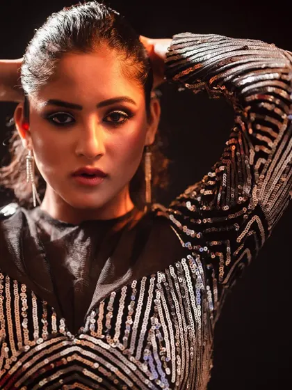 A direct and powerful pose in the same sequined outfit. This full-body shot showcases the entire look with a strong, confident stance.