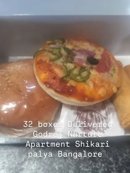 A burger, mini pizza and spring rolls fill this box from our delivery to Godrej Nurture Apartment in Shikaripalya, Bengaluru.