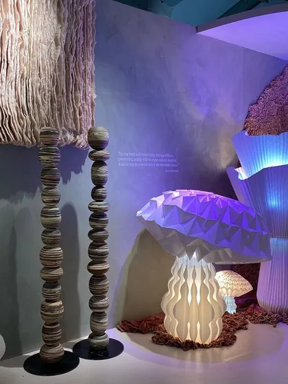Glowing mushroom-like lamps and textured totems in the 'Shroom' installation. The space is an immersive walkthrough inspired by the free-flowing organic forms and surfaces of the mycelic world.