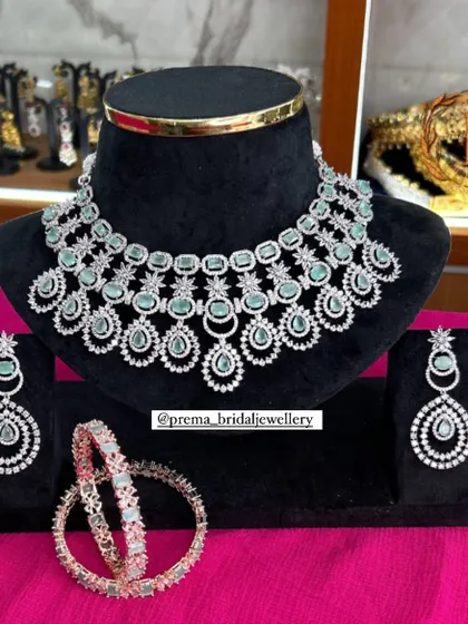 A modern and chic AD necklace set with matching earrings and bangles. The pastel green stones make it a perfect choice for engagement parties or pre-wedding events.