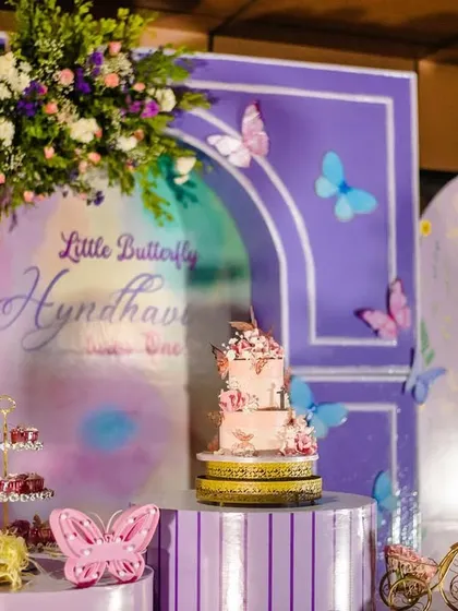 A close-up of the beautiful, multi-tiered butterfly cake. The delicate sugar butterflies and soft colors make it a true centerpiece of the celebration.