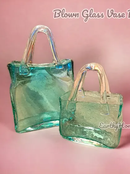 A truly unique piece, our blown glass handbag vase is a work of art. Use it to hold a small bouquet or as a standalone sculpture to wow your guests.