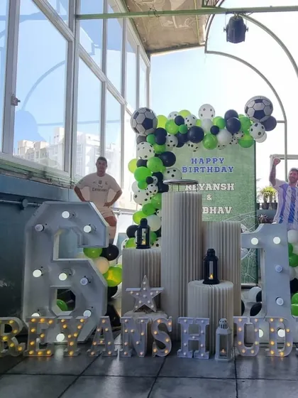 A full view of the rooftop football-themed party, showing the impressive scale of the marquee numbers.