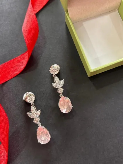 A perfect festive pick, these drop earrings feature a soft pink stone and diamond-studded leaves. They are designed to add just the right amount of sparkle and elegance to your celebrations.