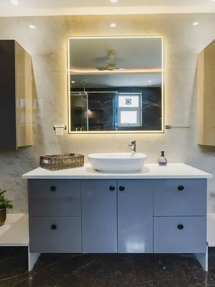 A spacious and practical bathroom vanity with plenty of storage. The large illuminated mirror is both functional and adds a touch of glamour.