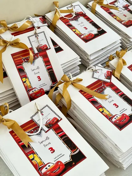 The vibrant red and gold theme of these "Cars" bags makes them an exciting and visually appealing party favour.