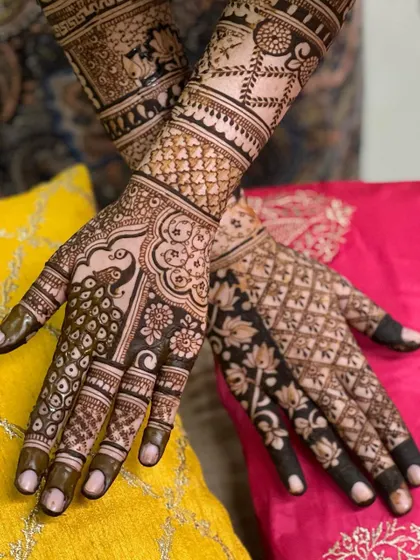 A close-up of the palms, featuring a peacock on one hand and a lotus pattern on the other, both executed with fine detail.