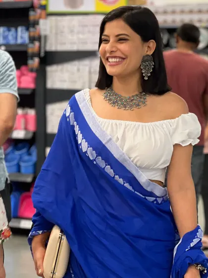 This happy moment shows how accessories can tie an entire outfit together. The customer's traditional silver necklace and earrings are beautifully balanced by the modern, artistic clutch.