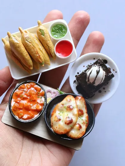 A handful of delicious-looking miniatures, including naan with curry, mirchi bajji, and a brownie with ice cream.