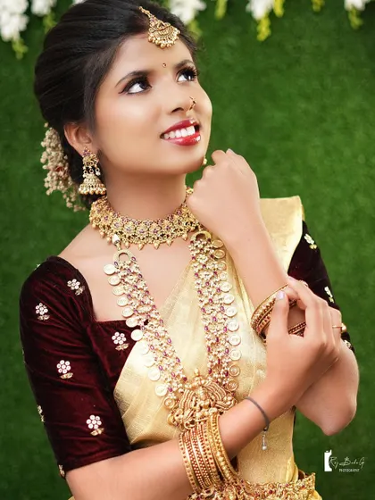 A joyful, candid shot of a model during a bridal photoshoot. The makeup is designed to look great both on camera and in person, capturing her radiant smile.
