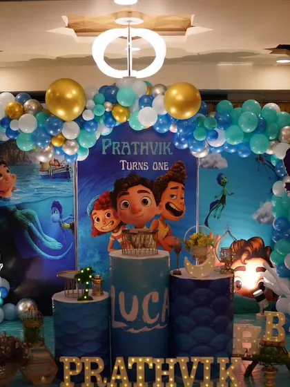 We dove into the Italian Riviera for this Luca-themed first birthday for Prathvik. The decor features an ocean-blue balloon arch, a backdrop with Luca and Alberto, and themed pedestals to capture the spirit of the seaside adventure.