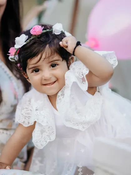 The pure, unfiltered joy of childhood. This close up portrait of a little girl in her lace dress and flower crown captures her playful spirit and sweet innocence during a family photography session.