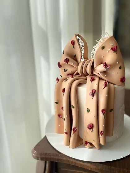 This elegant cake features a large, patterned bow with delicate floral details. Learn to add texture and patterns to your fondant for a unique, couture-inspired look.