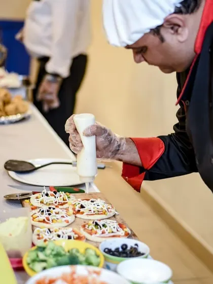 Our chef is caught in action preparing mini pizzas at a live counter. This interactive element adds a burst of flavor and fun to any party.