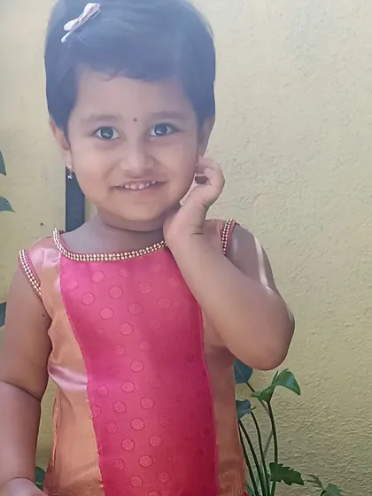 A sweet girl in a pattu pavadai, enjoying the Ugadi festivities.