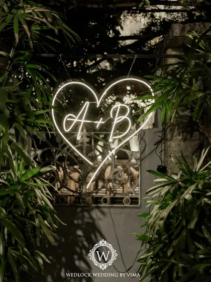 A custom neon sign with the couple's initials inside a heart. This was a perfect photo-op element for their cocktail night, adding a fun and modern vibe.