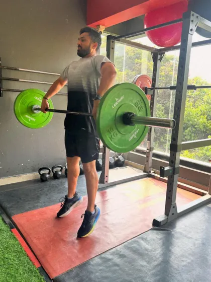 A client performs an upright row, targeting the shoulders and upper back.