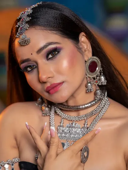 A close-up that highlights the purple and black smokey eye, a bold choice that pays off beautifully with the silver jewelry.