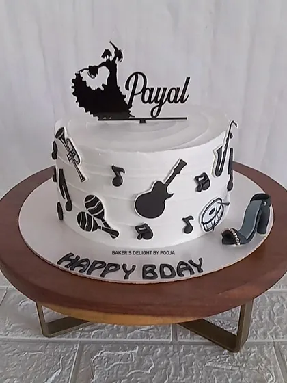 A cake for a dancer and music lover. This black and white design features musical instruments, notes, and a silhouette of a flamenco dancer, capturing all of her passions in one edible creation.