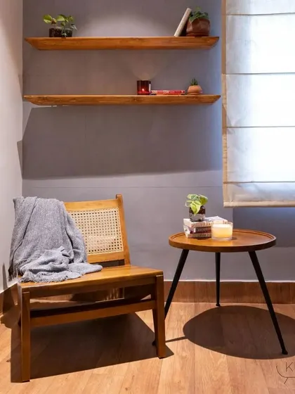 A custom-made teak and rattan chair paired with a side table, creating a simple yet elegant reading corner.