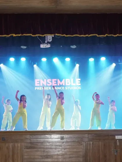 The 'Ensemble Premier Dance Studios' logo on the screen behind our youngest performers. We give every student a professional-level experience.