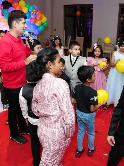 Interacting with the kids during a balloon game, keeping the atmosphere light and playful.