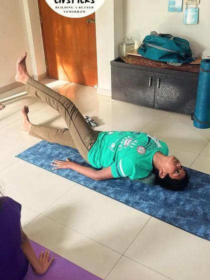 A young boy practices a reclining twist, a gentle pose that helps to release tension in the spine and improve digestion.