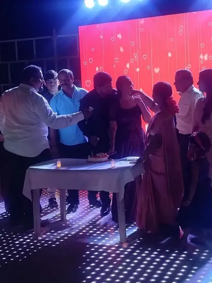 Another angle of a family celebrating a special occasion with a cake cutting on the sangeet stage. These moments of shared joy bring families closer together.