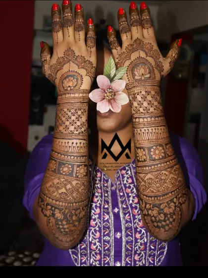 A full view of a traditional bridal mehendi design, held up to showcase the symmetry and extensive coverage for the big day.