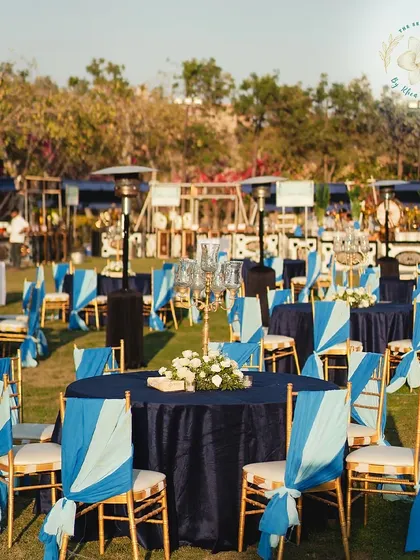 A wide view of the blue and gold themed Mehendi Sangeet setup. The cohesive color scheme ties the entire outdoor space together beautifully.