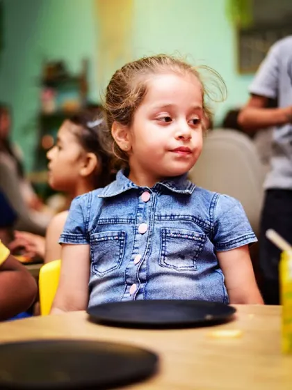 Waiting patiently for her slice of pizza. My cafe serves a variety of kid-friendly favorites to keep everyone happy and fueled for fun.