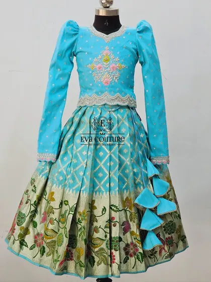 The long-sleeved lehenga design in a bright turquoise blue.
