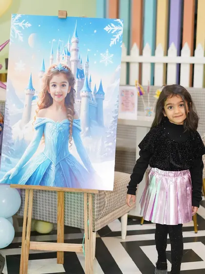 The birthday girl stands next to a personalized welcome poster featuring a princess that looks just like her, adding a special touch to her Frozen-themed party.