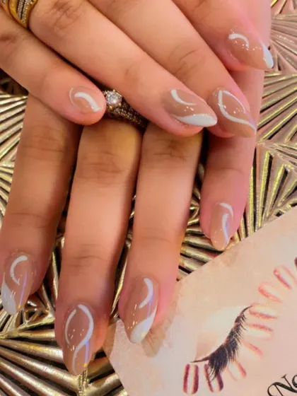 An elegant abstract design on almond-shaped nails. The nude base is decorated with delicate white and grey swirls for a soft, modern look.