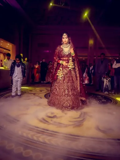 A grand bridal entry, with the bride standing in a circle of fog on the dance floor, illuminated by spotlights.