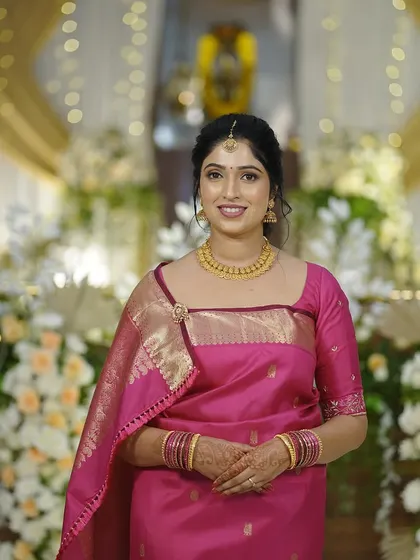 A full-length portrait of the bride. Her makeup, hair, and saree come together to create a beautiful and cohesive look.