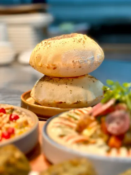 Freshly baked-to-order Pita Bread, puffed up and served warm. It's a humble but essential part of our menu, perfect for dipping into our flavourful hummus.