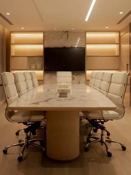 The conference room at Stone Boulevard features a massive marble table and soft, ambient lighting. The space is designed to feel luxurious and substantial, reflecting the quality of the brand.